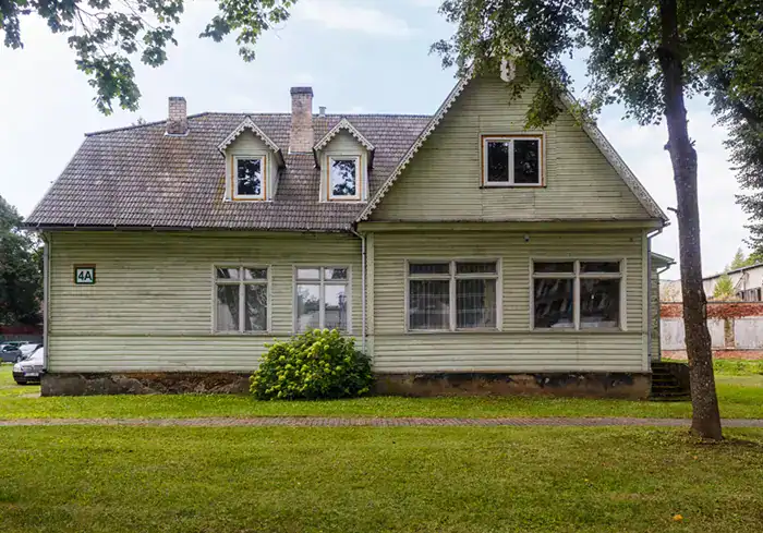 Older rundown house with faded siding and green lawn
